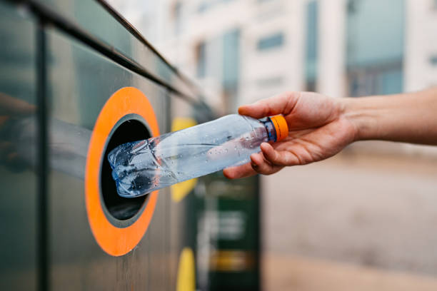 jovem reciclando uma garrafa de água em malmo na suécia - recycling recycling symbol environmentalist people - fotografias e filmes do acervo