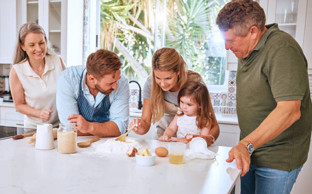 grandparents, parents and child baking in kitchen have fun, bond and learning together. big family, love and mom and dad teaching girl to cook, bake and develop chef skills with grandpa and grandma - two parent family indoors home interior domestic kitchen imagens e fotografias de stock