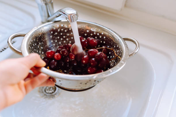 bunch ripe red grapes washed in colander in kitchen