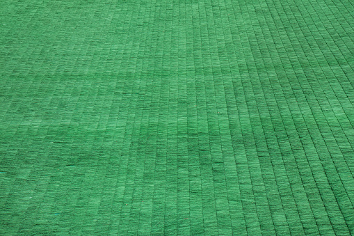 Igelit green plastic matting of ski jumping hill background