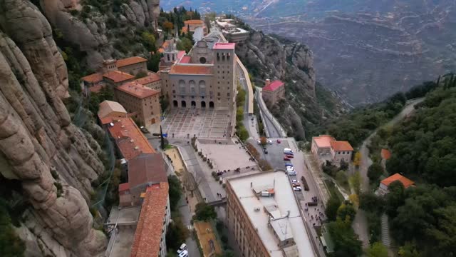 Ascending drone footage of Santa Maria de Montserrat Abbey on Montserrat mountain, Catalonia, Spain