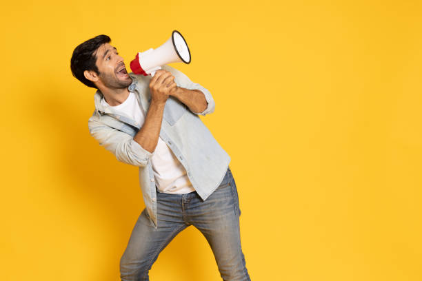 istock Young man holding megaphone isolated on yellow background, Speaker and announce concept 1796647983