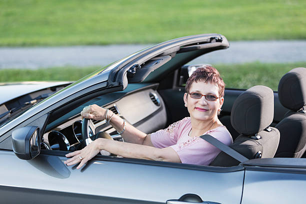 mature femme conduire voiture décapotable - sc0631 photos et images de collection