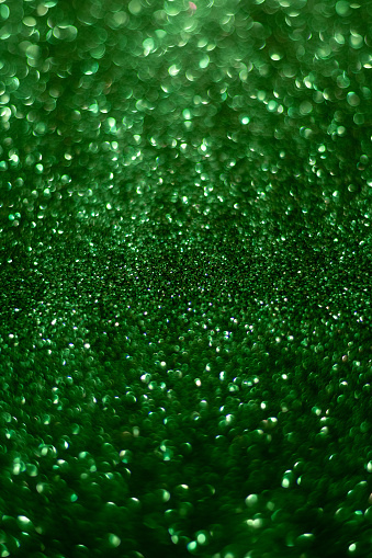 Abstract green shiny blurred background with space for text.  Vertical  photo.