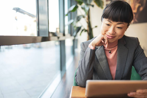 istock Smiling woman using digital tablet to read newspaper 1796669951
