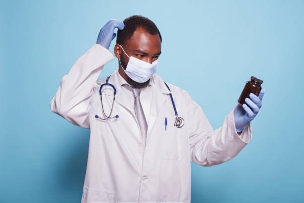 istock Baffled Male Doctor Holding Pill Bottle 1796674460