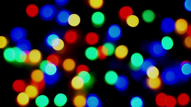 Footage defocused blurry still motion of multicolored blinker lights bokeh of Christmas and New year decoration lights, abstract, dark background, overlay for party, shallow DOF