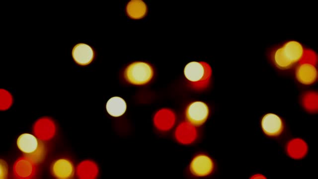 Footage defocused blurry panning motion of multicolored blinker lights bokeh of Christmas and New year decoration lights, abstract, dark background, overlay for party, shallow DOF