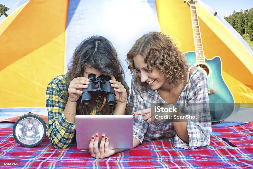 Acampamentos: Amigos olhando Tablet com binóculos em uma barraca - Foto de stock de 20 Anos royalty-free