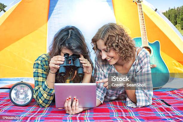 Foto de Acampamentos Amigos Olhando Tablet Com Binóculos Em Uma Barraca e mais fotos de stock de 20 Anos