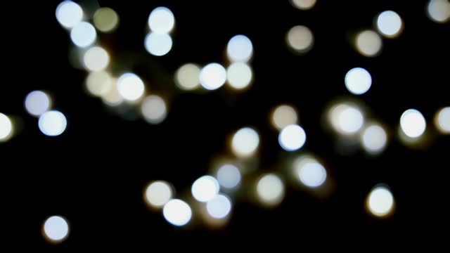 Footage defocused blurry still motion of white blinker lights bokeh of Christmas and New year decoration lights, abstract, dark background, overlay for party, shallow DOF