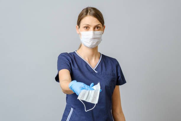 istock Young female doctor offering a face mask 1796692254