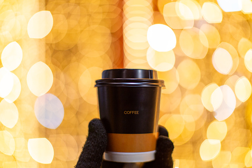 Embrace the urban rhythm with this captivating photograph capturing the essence of city life. A hand gently cradles a 'Coffee to Go' cup, adorned by the soft glow of bokeh lights that dance in the city's backdrop. This image epitomizes the on-the-go lifestyle, where warm moments are savored amidst the hustle and bustle. The warm tones and play of light create a cozy atmosphere, inviting you to join the city's heartbeat. Whether you're a busy commuter or a casual explorer, this photo encapsulates the simple joys found in a comforting cup of coffee against the vibrant canvas of urban lights. Drink in the warmth of the moment and let the city's energy resonate with your own.