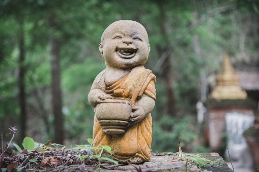 A happy smiling statue of a Monk