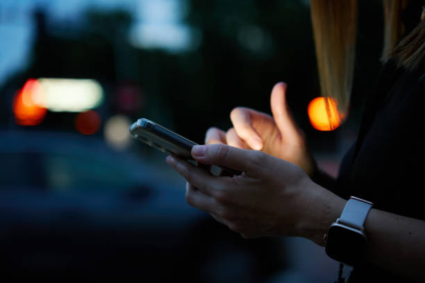 istock Woman using smartphone at evening street 1796715809