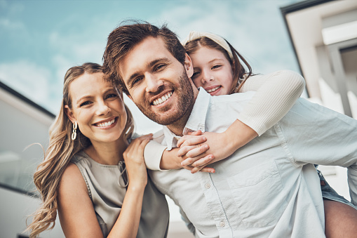 Portrait, family and piggyback outdoor at new home, real estate loan and building mortgage together. Parents, kid and smile outside for property investment, moving house and security for happy future