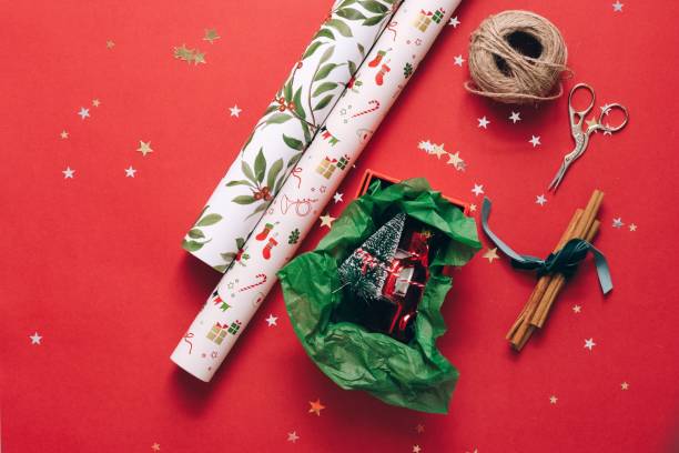 istock Rolls of gift wrapping paper with twine and scissors on a red surface 1796741101