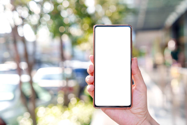 istock A hand holding a mobile smartphone with a blank screen, set against a blurred street background 1796748640