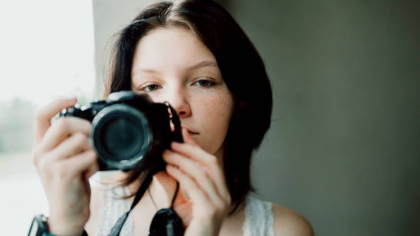 Transgender non-binary teenager with a camera, hobby photographer