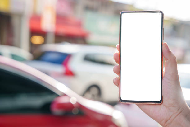 istock A hand holding a mobile smartphone with a blank screen, set against a blurred street background 1796759790