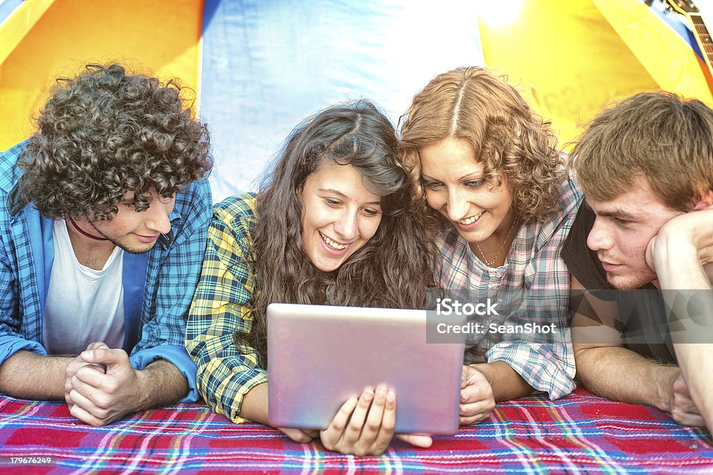 Campamento: Amigos mirando tableta en una tienda - Foto de stock de 20 a 29 años libre de derechos