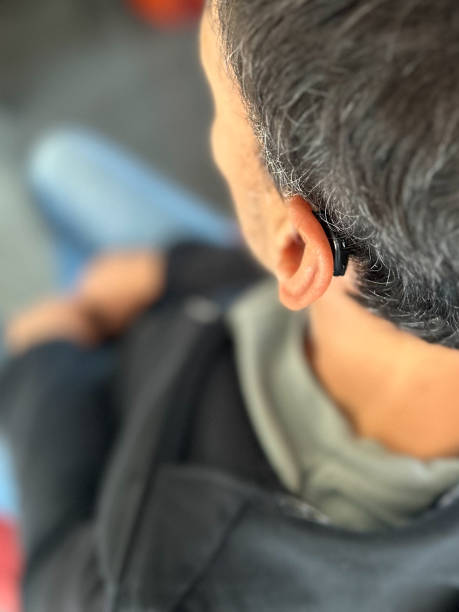 istock Close-up of ear with hearing aid put on Deaf man 1796771931