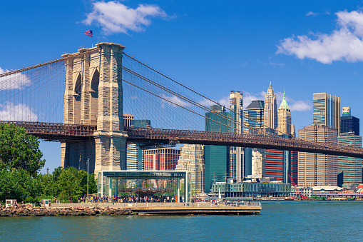 High Resolution Stitched Image of Brooklyn Bridge, Skyscrapers of Manhattan Lower East Side Financial District, FDR Drive, Pier 17, Brooklyn Bridge Park and Water of East River. Blue Morning Sky with Puffy Clouds is in background, New York City, USA. Canon EOS 6D (full frame sensor) DSLR and Canon EF 85mm F/1.8 Prime lens. 3:2 Image Aspect Ratio.