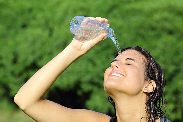 istock Attractive woman throwing herself water from a bottle 179680255