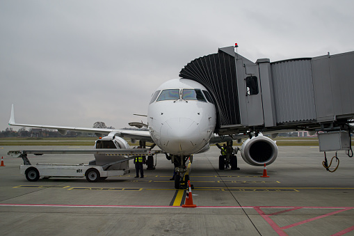 Aircraft shortly after arrival parked at the gate with an airbridge connected at Lviv Airport