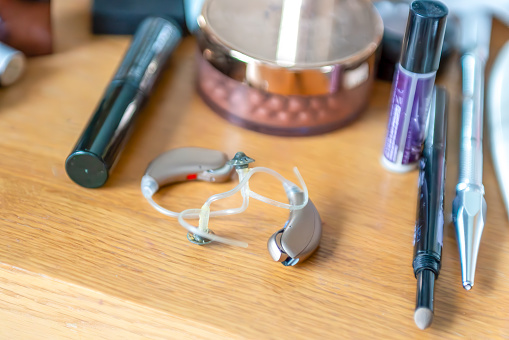 Modern digital hearing aids with make up on a dressing table.