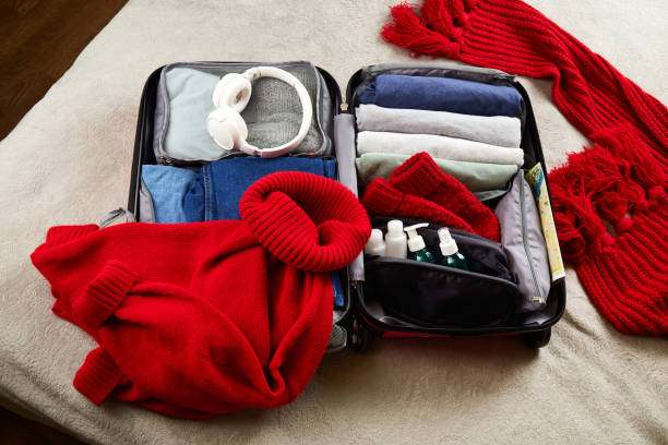 istock An open suitcase with warm clothes, documents and accessories for winter travel 1796820717