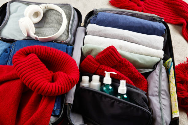 istock An open suitcase with warm clothes, documents and accessories. The concept of travel 1796820721