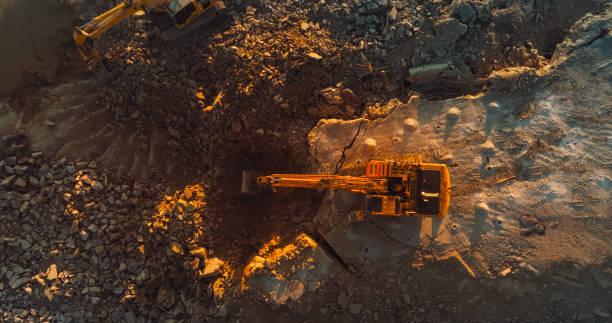 istock Aerial Drone Shot Directly Above Industrial Excavator Digging Up Rocks On Construction Site On Sunny Day. Workers Operating Machinery To Complete Real Estate Project Or Extract Natural Resources 1796824534