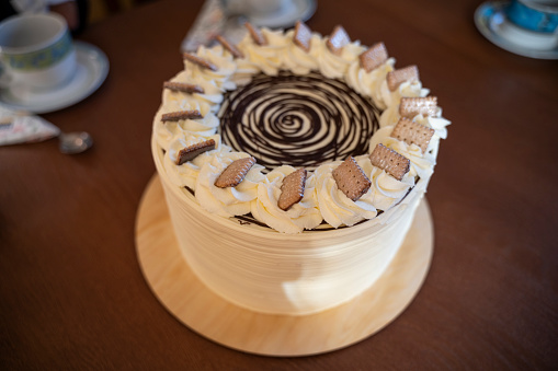 Side view of a cake decorated with cookies and cream and chocolate on the table.