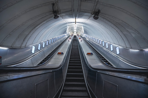 Escalators in an empty tube station late at night during the weekend in London.