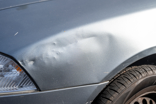 Dented fender on car after an auto accident.