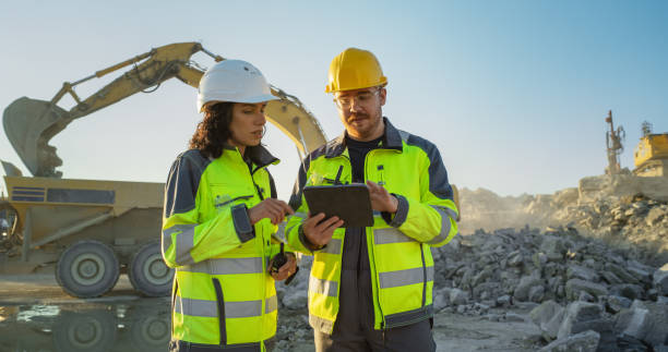 istock Caucasian Male Civil Engineer Using Tablet And Talking To Hispanic Female Architect On Construction Site Of New Real Estate Project. Diverse Colleagues Discussing Building Plan Of Apartment Block. 1796833231