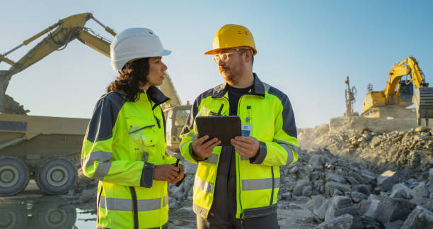 istock Caucasian Male Civil Engineer Using Tablet And Talking To Hispanic Female Architect On Construction Site Of New Real Estate Project. Diverse Colleagues Discussing Building Plan Of Apartment Complex. 1796833592