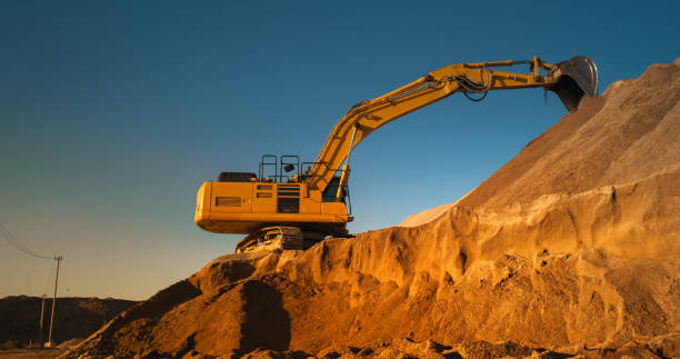 istock Construction Site On A Sunny Day: Industrial Excavator Digging Sand To Lay Foundation for Building New Apartment Complex. Workers Operating Heavy Machinery To Complete A Real Estate Project On Time. 1796841373