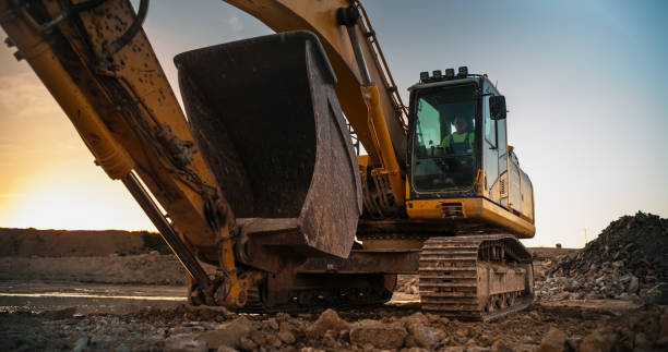 istock Construction Site On Sunny Evening: Industrial Excavator Driving To Complete Work Tasks Related To Building New Real Estate Project. Man Operating Heavy Machinery To Build Apartment Complex. 1796841920