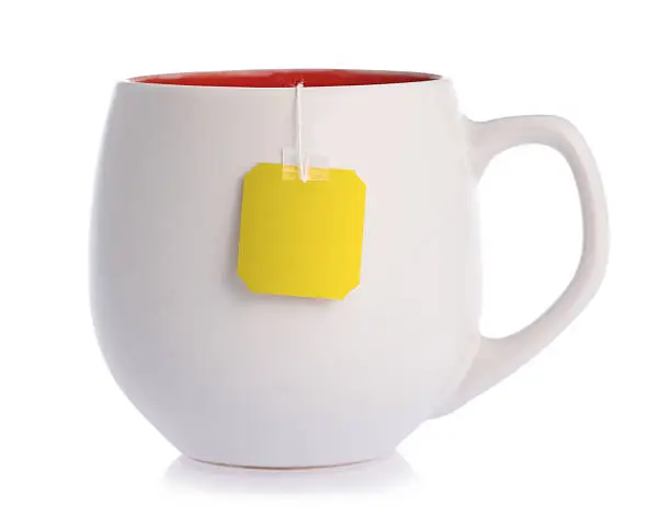 White ceramic mug with teabag label, isolated on a white