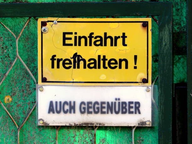Keep the driveway clear! Also opposite. Keep the entrance clear. Weathered Sign.