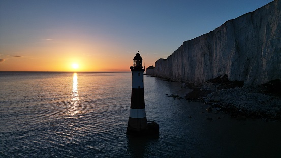 A scenic view of Beachy Head Lighthouse at sunset