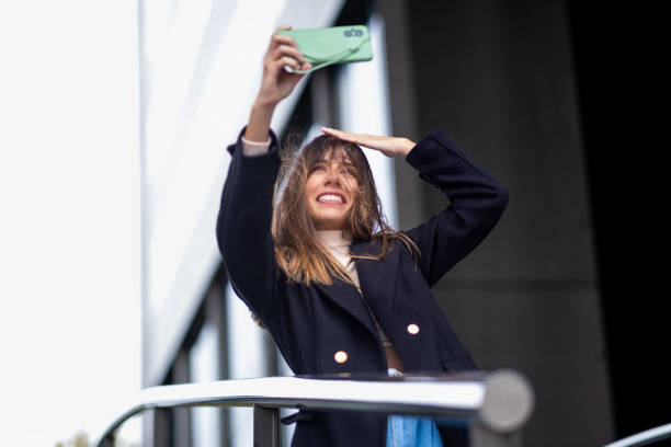 Woman captures fun moments with windblown selfies.