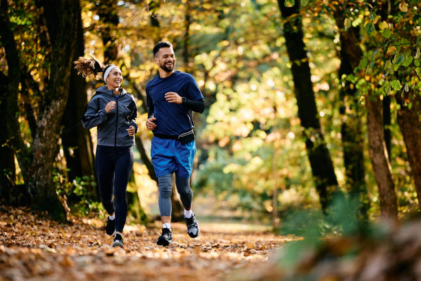 istock Happy athletic couple jogging through the park. 1796859252
