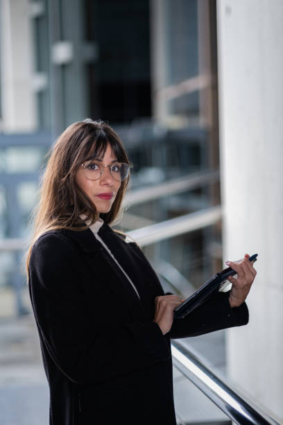 istock Smiling woman with tablet, corporate setting. 1796859316