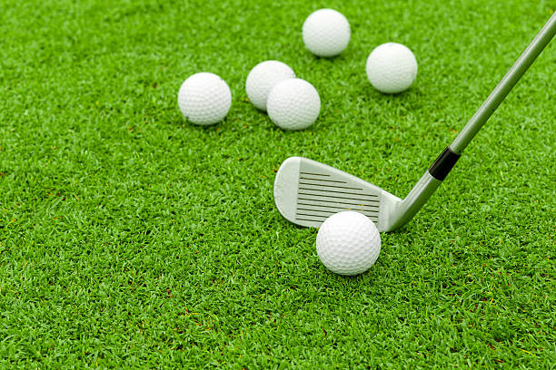 istock golf ball  tee in front of driver on green course 179687858