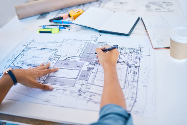 istock Architect sketching, planning or drawing an architectural design plan or blueprint diagram with draw tools, equipment and stationery. POV hands of man busy working on new designing project structure 1796900880