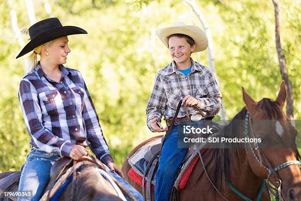 Giovane Cowboy E Una Cowgirl Cavalcare Cavalli Durante La Cavalcata - Fotografie stock e altre immagini di Bambino