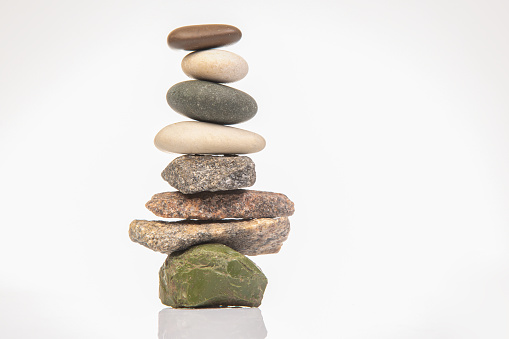 Subject: The zen of five pebbles stacked in a column. Isolated on a white background.